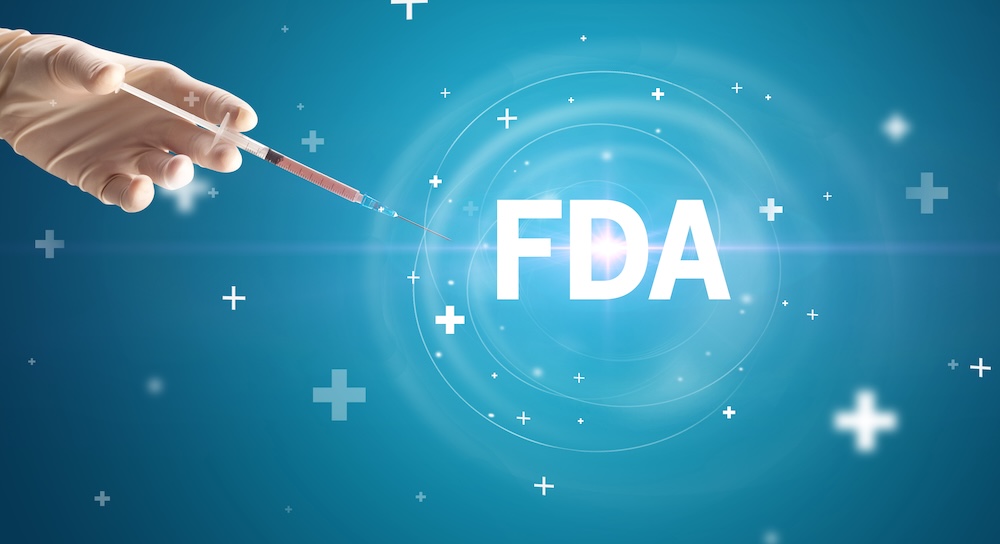 Hand holding a syringe with the letters FDA