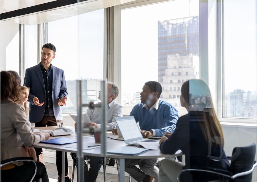 Successful business man talking to a group of people in a meeting a the office
