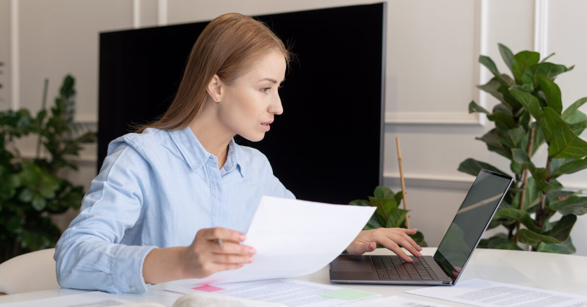 0523_NSM_Blog_AllCompRoughNotes Woman working on her laptop holding papers