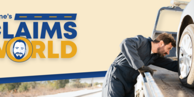 Wayne’s Claims World logo, photo of tow truck operator loading a car on a tow truck