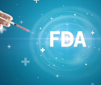 Hand holding a syringe with the letters FDA