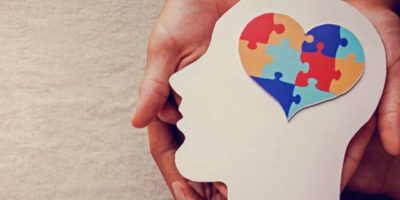 image of hands holding a head shaped cardboard with a puzzle piece inside