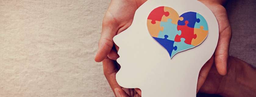 image of hands holding a head shaped cardboard with a puzzle piece inside