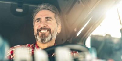 Photo of man in drivers seat of tractor trailer