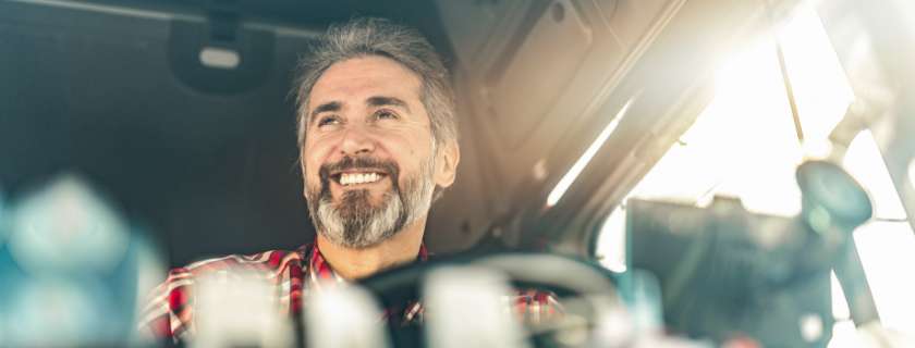 Photo of man in drivers seat of tractor trailer