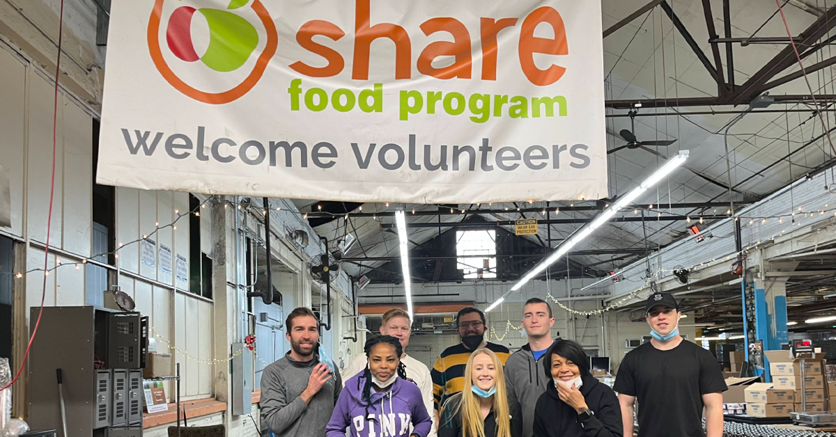 Photo of several people volunteering at a food bank`